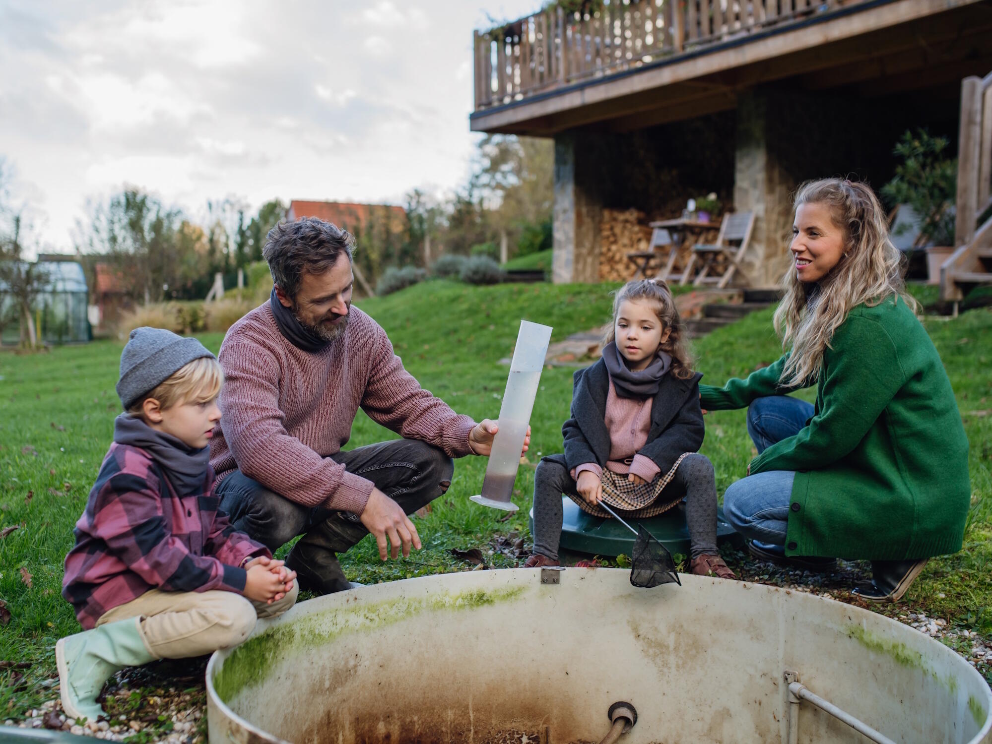 Familie nimmt Wasserprobe an einem Brunnen im Rahmen eines außerschulischen Wasser-Lernortes.