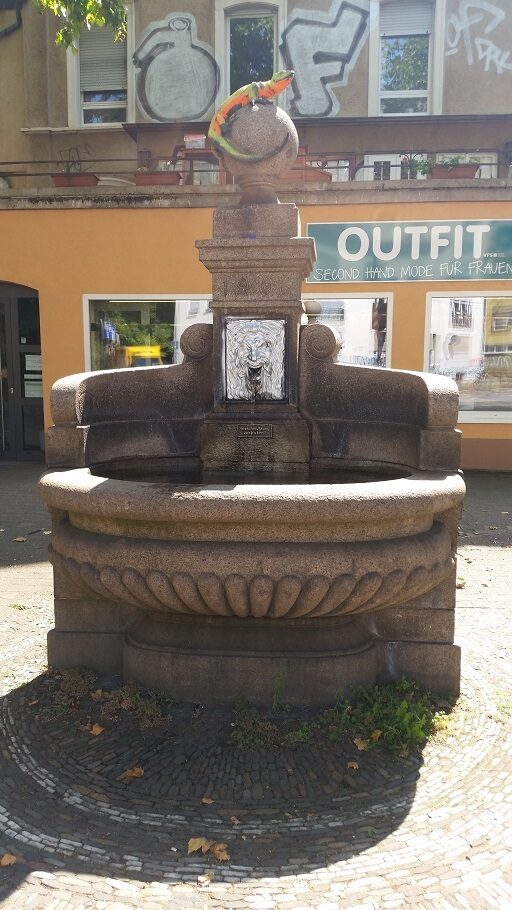 Trinkwasser Brunnen aus Granit mit Echse auf der Säule des Brunnens