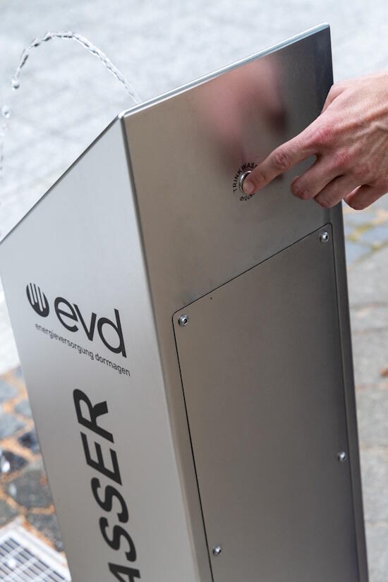 Edelstahl Trinkbrunnen auf dem Paul-Wierich-Platz in Dormagen. Auf Knopfdruck läuft vorne das Wasser.